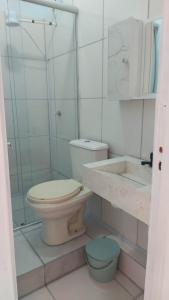 a white bathroom with a toilet and a sink at Calçadão balneário Camboriú in Balneário Camboriú +18 photos