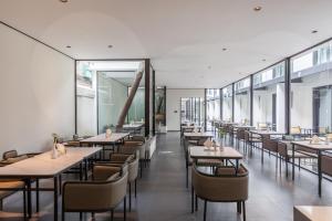 - une salle à manger avec des tables, des chaises et des fenêtres dans l'établissement Gongxili - Xige Hotel, à Chengdu