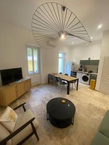 un salon avec une table et un grand lustre dans l'établissement Superbe appartement à 5 minutes à pied de la mer, à Toulon