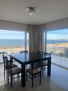 a dining room table and chairs with a view of the ocean at Vista al Mar in Puerto Madryn