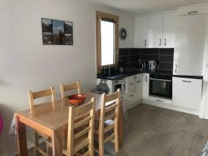 a kitchen with a wooden table and a table and chairs at Paradiski proche des pistes plan peisey in Peisey-Nancroix