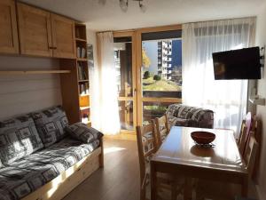 a living room with a couch and a table at Paradiski proche des pistes plan peisey in Peisey-Nancroix