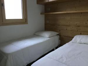 two beds in a small room with a window at Paradiski proche des pistes plan peisey in Peisey-Nancroix