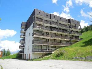 a large building with balconies on the side of a hill at Paradiski proche des pistes plan peisey in Peisey-Nancroix