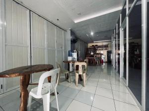 um corredor com uma mesa e cadeiras num edifício em A and A Bed and Breakfast Inn powered by Cocotel em Legazpi