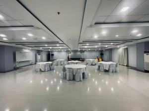 a conference room with white tables and a podium at A and A Bed and Breakfast Inn powered by Cocotel in Legazpi