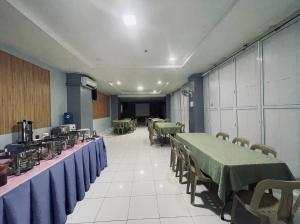 a row of tables and chairs in a room at A and A Bed and Breakfast Inn powered by Cocotel in Legazpi