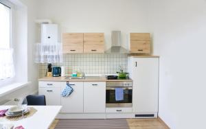cocina con armarios blancos y nevera blanca en Die ideale Wohnung, en Solingen
