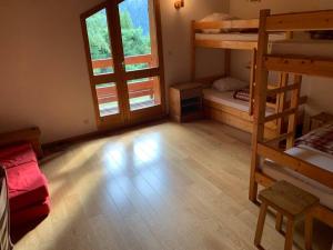 a room with two bunk beds and a wooden floor at Paradiski proche des pistes plan peisey in Peisey-Nancroix