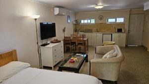 a room with a bed and a living room and a kitchen at Kfar Vradim Hosting in Kefar Weradim