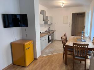 a kitchen with a table and a television on a wall at Wohnung in direkter Innenstadtlage in Potsdam