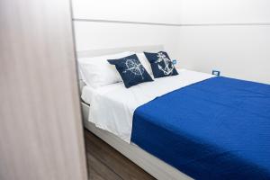 uma cama com lençóis e almofadas azuis e brancos em La Casa di Anna em Bagheria