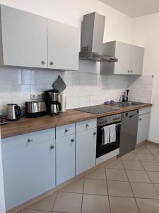 cocina con armarios blancos y fogones en Wohnung in direkter Innenstadtlage, en Potsdam