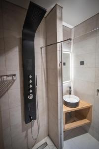 a bathroom with a shower with a sink at Mítosz Apartman in Gyomaendrőd