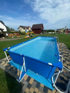 una piscina con un banco azul alrededor en Domki Magnati en Władysławowo