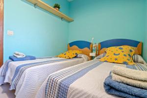 two beds in a room with blue walls at Residencial Los Pelicanos in Hospitalet de l'Infant +13 photos