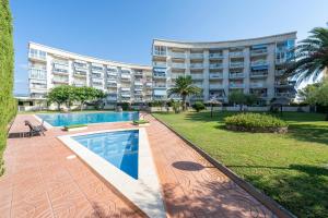 a large building with a swimming pool in front of a building at Residencial Los Pelicanos in Hospitalet de l'Infant