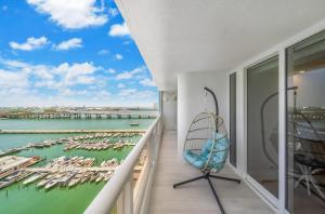 een balkon met een stoel en uitzicht op een jachthaven bij Blooming Sun Direct Ocean View in Miami