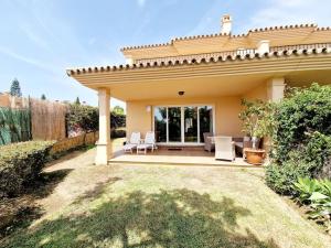 a house with a patio with white chairs at The best Villa in Los Flamencos in Mijas