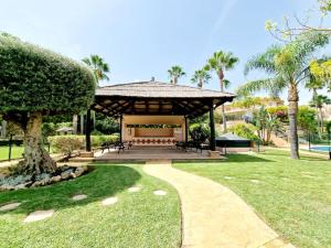 a pavilion in a park with palm trees and a path at The best Villa in Los Flamencos in Mijas