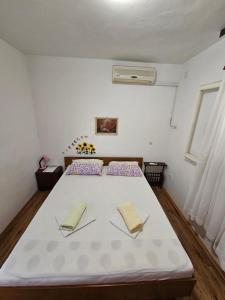 a bedroom with a large white bed with two pillows at Apartman Antica in Komiža