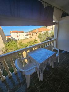a blue table and chairs on a balcony at Apartman Antica in Komiža
