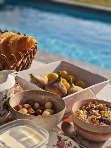 uma mesa coberta com taças de fruta e uma cesta de pão em Chambre de charme dans maison de maître em Montauban