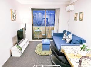 sala de estar con sofá azul y TV en Pyrmont 1BR Apt Walking-Darling HarbourCBDStar en Sídney
