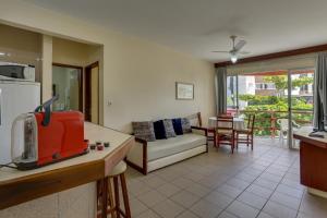 cocina y sala de estar con sofá y mesa en Canascenter Apart Hotel, en Florianópolis