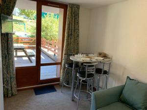 een kamer met een tafel en stoelen en een balkon bij Paradiski ski au pied vallandry in Landry