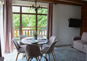 stół i krzesła w salonie z oknem w obiekcie Apartamenty Wilcza Knieja w Zawozie