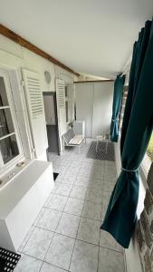 een badkamer met een bad en een tegelvloer bij Villa Stella 8pers. La Bourboule in La Bourboule