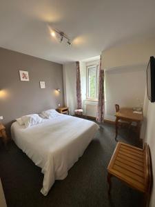 a bedroom with a large white bed and a window at Hôtel du Rangen in Thann