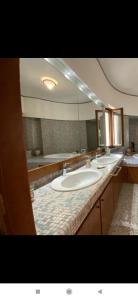 ein Badezimmer mit zwei Waschbecken und einem großen Spiegel in der Unterkunft La Terrazza Quisisana Sorrento Coast in Castellammare di Stabia