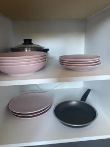 a kitchen with plates and bowls and a frying pan at Apartmani borova 2 in Veliko Gradište