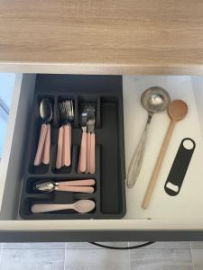 a tray filled with utensils in a drawer at Apartmani borova 2 in Veliko Gradište