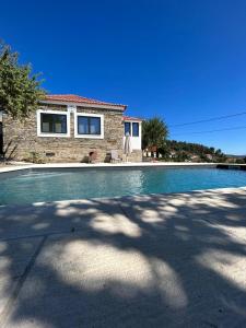 a swimming pool in front of a house at Domus Vila Maria Douro in Castanheiro do Sul