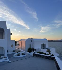 a view of a house with the ocean in the background at Santorini View in Akrotiri