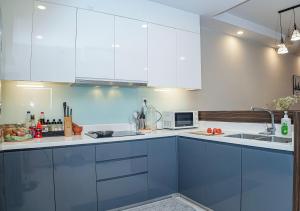 a kitchen with white cabinets and a sink at Louisa The Gold View Apartment in Ho Chi Minh City