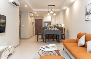 ein Wohnzimmer mit einem Tisch und einem Esszimmer in der Unterkunft Louisa The Gold View Apartment in Ho-Chi-Minh-Stadt