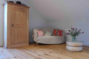 una sala de estar con sofá y un jarrón de flores en Ferienwohnung Manu, en Kisslegg