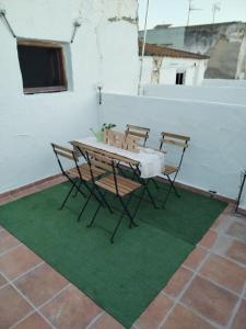 una mesa y sillas sobre una alfombra verde en Apartamentos La Campana 1, en Jerez de la Frontera