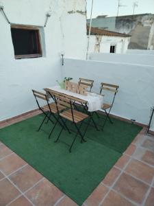 a table and chairs sitting on a green rug at Apartamentos La Campana 1 in Jerez de la Frontera