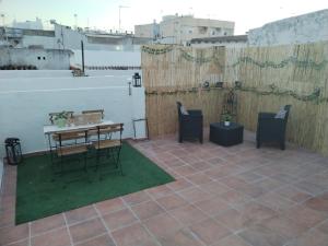a patio with a table and chairs on a roof at Apartamentos La Campana 1 in Jerez de la Frontera