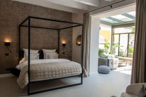 een slaapkamer met een hemelbed en een patio bij JK Moulin Paradou in Paradou
