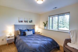 a bedroom with a blue bed and a window at Modern Bellingham Retreat Near Galbraith Mountain! in Bellingham