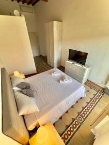 - une chambre avec un grand lit et une télévision dans l'établissement Lungarno Suite, à Pise