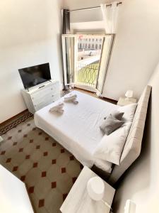 - une chambre avec un grand lit et une télévision dans l'établissement Lungarno Suite, à Pise