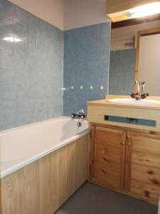 ein Badezimmer mit einer Badewanne und einem Waschbecken in der Unterkunft Paradiski ski au pied vallandry in Landry