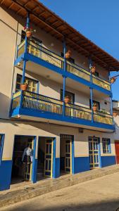 a blue and white building with a balcony at Hotel Dorado Jardín in Jardin